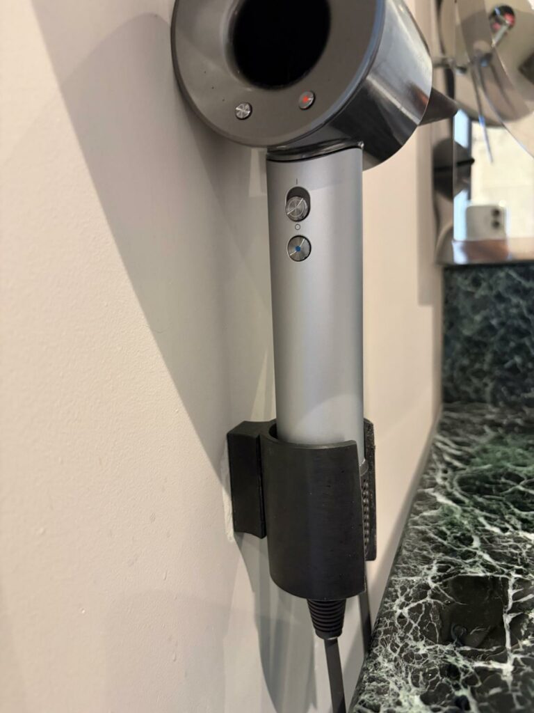 Ancien support mural de sèche-cheveux Dyson dans une salle de bain d'hôtel de luxe à Cannes